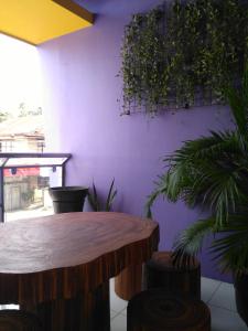 塔比拉兰Bohol Coop Tourist Inn的一间设有木桌和紫色墙壁的客房