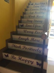 塔比拉兰Bohol Coop Tourist Inn的楼梯间,楼梯上写着字,楼梯上写着幸福的楼梯