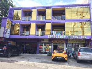塔比拉兰Bohol Coop Tourist Inn的停在大楼前的黄色汽车