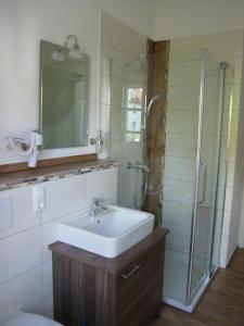 菲尔斯比堡Pension Lechner的一间带水槽和玻璃淋浴的浴室
