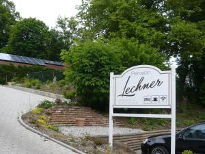 菲尔斯比堡Pension Lechner的花园前的标志,有建筑