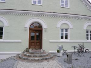菲尔斯比堡Pension Lechner的白色的房子,设有木门和庭院
