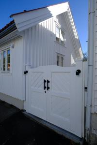 拉尔维克Sjøgata Gjestehus的白色车库,有白色门和建筑