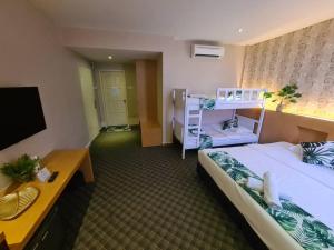 马六甲Grandeur Hotel And Spa的酒店客房设有两张床和一台平面电视。