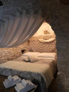 阿尔贝罗贝洛Trulli Aria di Casa的卧室配有一张石墙床