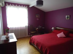 CarignanA la Cerisaie的一间卧室设有红色的床和窗户。