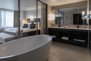 赫尔辛基Lapland Hotels Bulevardi的带浴缸的浴室和卧室