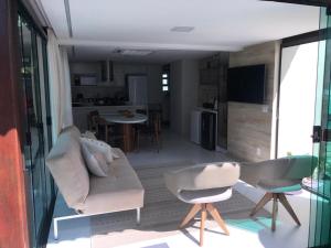 嘎林海斯港Muro Alto Residence的带沙发和椅子的客厅以及厨房。