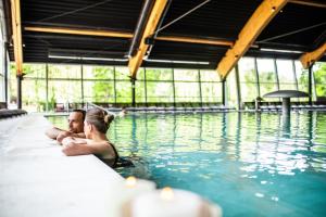 圣马丁娜穆里Hotel Terme Sveti Martin的坐在游泳池里的男人和女人