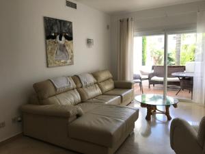 EsteponaApartment Costalita, direct beach access, ground floor, salt water pool的客厅配有沙发和桌子