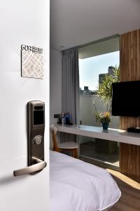 台中市希堤微旅 - 逢甲店的酒店客房设有一张床和一张带电视的书桌。