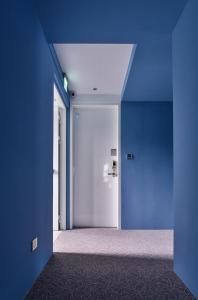 台中市希堤微旅 - 逢甲店的一条空的走廊,有蓝色的墙壁和门