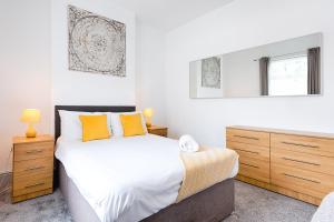 斯旺西Walking Distance to the Liberty Stadium - TV in every Bedroom!的一间卧室配有一张带橙色枕头的大床