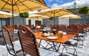 博登迈斯Resort Hotel的庭院里配有一张带椅子和遮阳伞的木桌