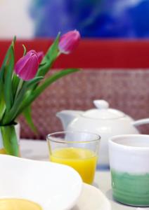 慕尼黑第一克里提夫大象酒店的一张桌子,上面放着花瓶和一杯橙汁
