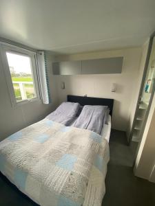 Westerland查姆洛基瓦佐特度假屋的一间小卧室,配有一张带窗户的床