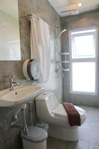 卡塔海滩Kata Bai D - SHA Certificate Hotel的一间带卫生间、水槽和窗户的浴室