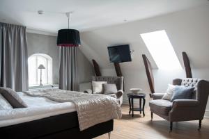 维斯比斯洛兹贝肯酒店的一间卧室配有一张床、一把椅子和电视。