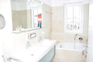 卡普伦Avenida Mountain Resort A11的一间带两个盥洗盆、浴缸和窗户的浴室