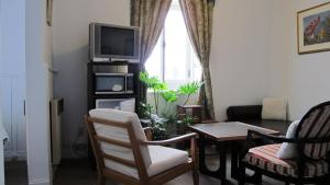 魁北克市奥佩提特酒店的客厅配有电视和桌椅