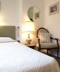 魁北克市奥佩提特酒店的一间卧室配有一张床、一把椅子和镜子