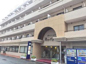 川崎Sky Heart Hotel Kawasaki - Vacation STAY 97869的街道上一座大型建筑,有商店