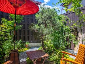 高山Tabino Shiori - Vacation STAY 83814的一个带红色遮阳伞和桌椅的庭院