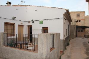 莱图尔Casa Rural Manuel y Dolores的阳台上有围栏和狗的建筑