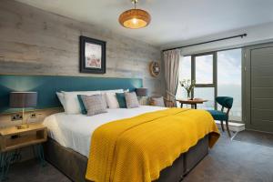 森嫩湾圣奥斯特尔啤酒厂成功老旅馆的一间卧室配有一张带黄色毯子的大床