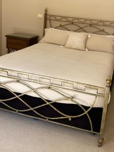 伊丘卡阿卡夏露台别墅的一张带金属框架和白色床单及枕头的床