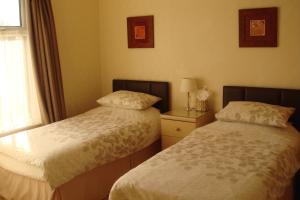博尔顿温多弗旅馆的一间卧室设有两张床和窗户。