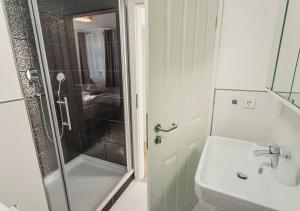 拉尔Ferienwohnungen und Boardinghouse Heimbach in Lahr的带淋浴和盥洗盆的白色浴室