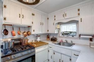 罗克波特Bell Buoy的厨房配有白色橱柜、炉灶和水槽。