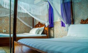 卡塞斯Sandton Hotel Kasese的一间卧室配有两张床和紫色窗帘