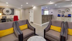 辛辛那提克莱蒙贝斯特韦斯特酒店的客厅配有两把椅子和黄色枕头