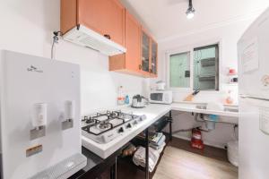 首尔Itaewon Yellow Guesthouse的厨房配有白色家电和木制橱柜