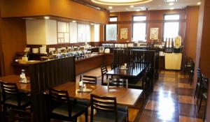 十和田十和田航线客栈酒店的一间带木桌椅的餐厅和一间酒吧