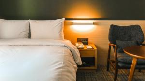 天安市开城大酒店 的配有床、椅子和桌子的酒店客房