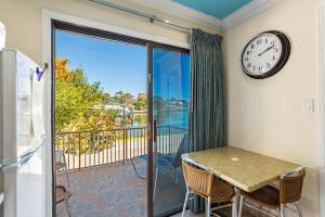 圣徒皮特海滩湾景广场海滨度假酒店的一间带时钟的用餐室和一个带桌椅的阳台