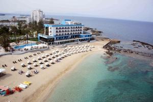 法马古斯塔Arkin Palm Beach Hotel的享有海滩的空中景致,配有遮阳伞和海洋