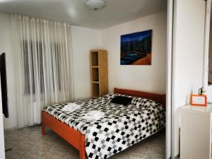KomenKrasen Kras Apartment的一间卧室配有一张带黑白毯子的床