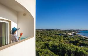 加利波利Ecoresort Le Sirene - Caroli Hotels的站在一个眺望海洋的阳台上的女人