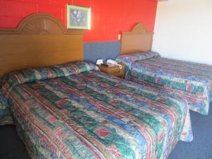 Adair阿达尔经济汽车旅馆的红色墙壁的酒店客房内的两张床