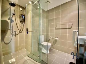 哥打京那巴鲁Homesuite' Home at Aeropod SOVO的浴室设有玻璃淋浴间和卫生间