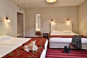 阿雅克修Hôtel Fesch & Spa的酒店客房,配有两张床,床上有一只动物塞满了东西