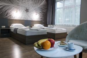 旧扎戈拉艾者若特酒店的一间设有两张床的房间和一张带水果的桌子