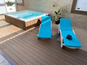 特尔德Chalet Canarias的甲板上的热水浴池,配有两把椅子和游泳池