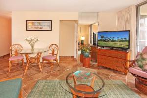 玛雷亚Island Sands Resort 305的客厅配有桌子和电视