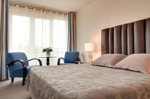 SolesmesGrand Hôtel de Solesmes - Teritoria的一间卧室配有一张大床和两张蓝色椅子