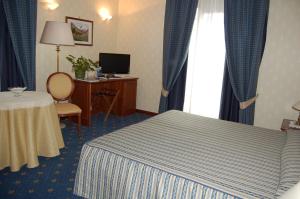 圣文森特奥林匹克酒店的酒店客房设有床、桌子和窗户。